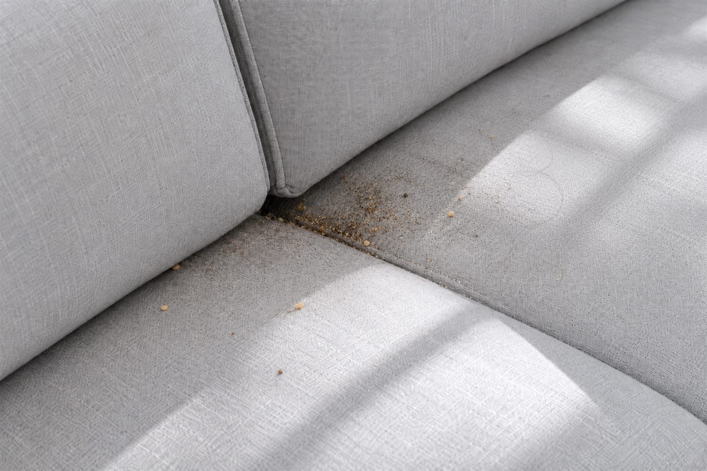 Khe ghế sofa còn bám bụi và vụn bẩn